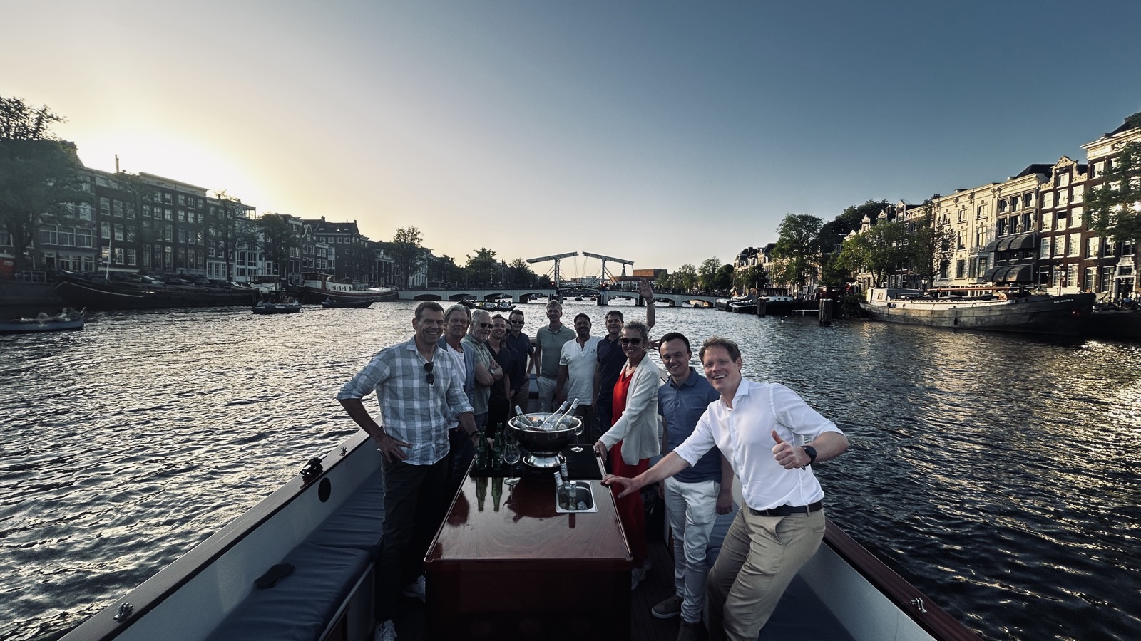 Software Combined team celebrating on an Amsterdam canal boat at sunset
